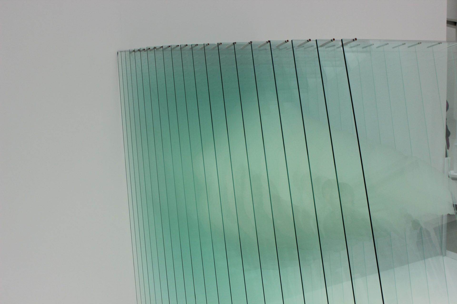 Abstract image showcasing a modern glass panel installation with reflections and a minimalistic design.