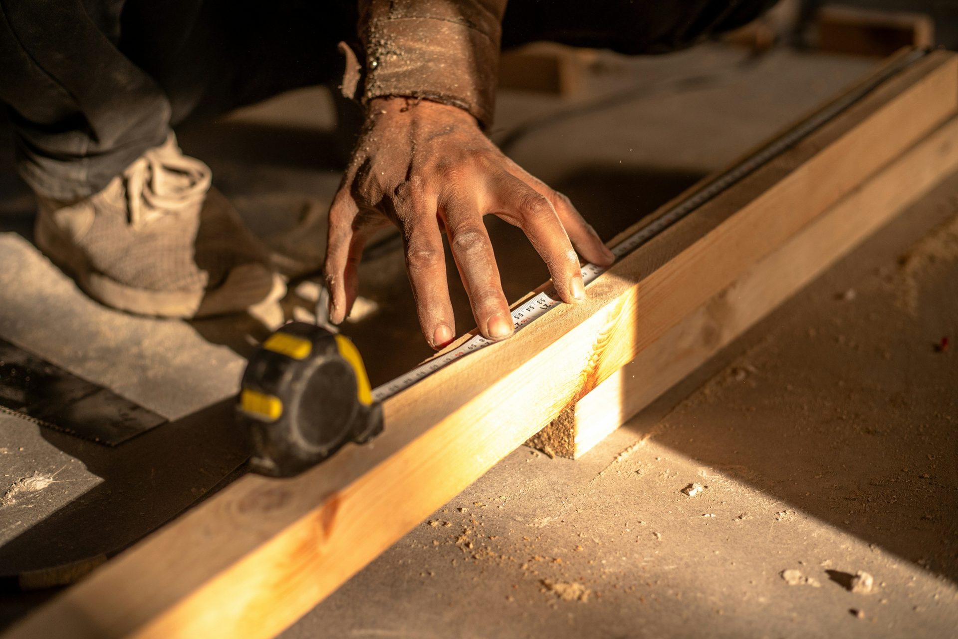 A man using a circular saw to cut a piece of wood